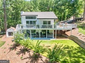 back of property featuring stairway, a patio, an outdoor structure, and a deck