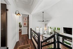 corridor featuring lofted ceiling, attic access, and wood finished floors