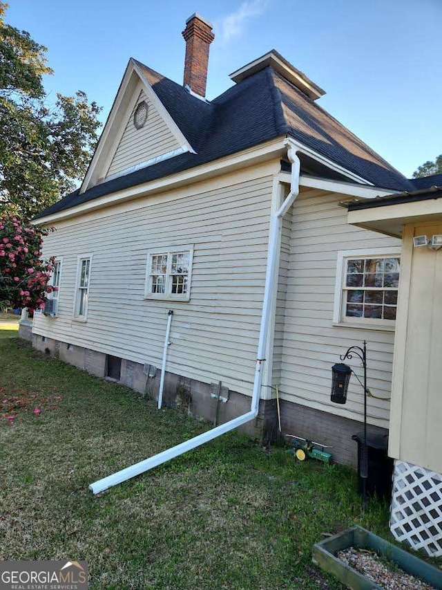 view of side of home featuring crawl space, a yard, and a chimney