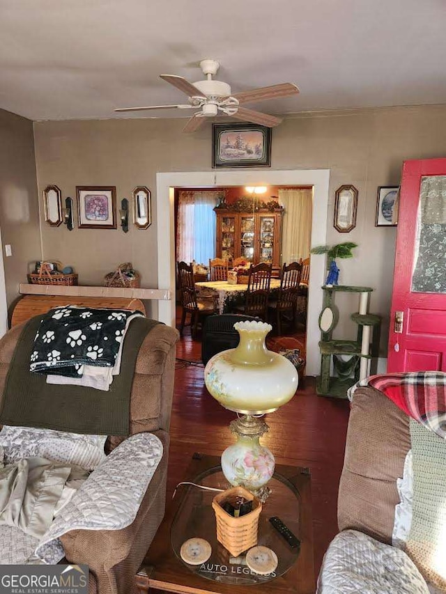 living area with wood finished floors and ceiling fan