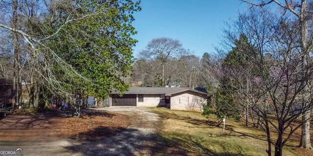 view of front of home with a garage and dirt driveway