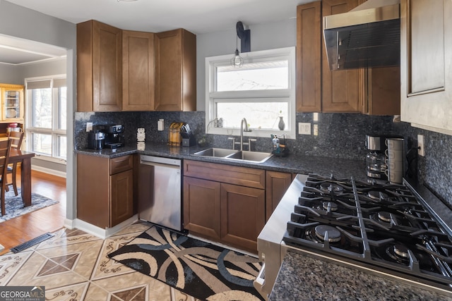 kitchen featuring visible vents, backsplash, ventilation hood, stainless steel dishwasher, and a sink