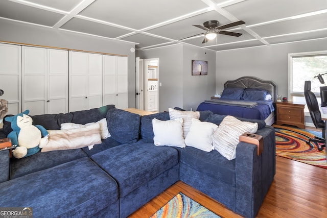 living area with a ceiling fan, wood finished floors, and coffered ceiling