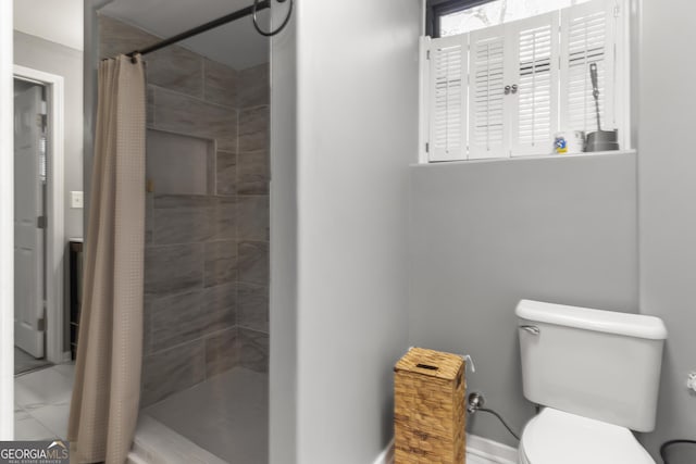 full bathroom featuring toilet, tiled shower, and marble finish floor