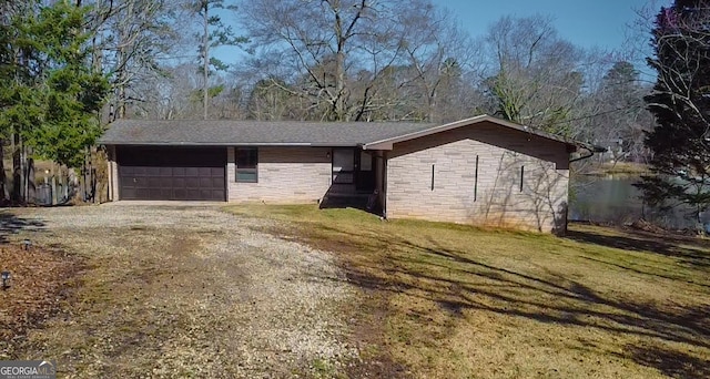 ranch-style house featuring a front lawn, an attached garage, stone siding, and driveway