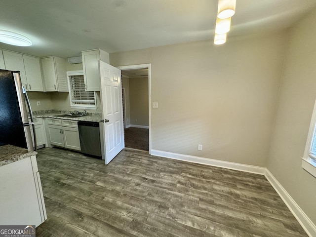 kitchen with a sink, stainless steel appliances, dark wood finished floors, and white cabinetry