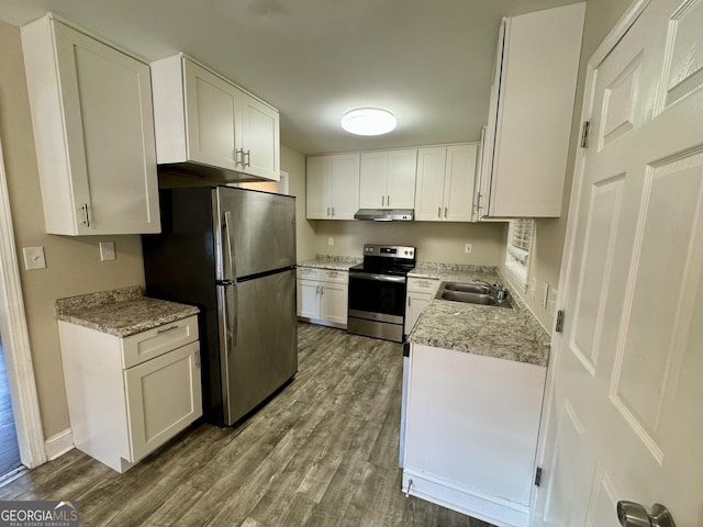 kitchen featuring under cabinet range hood, a sink, dark wood-style floors, stainless steel appliances, and white cabinets