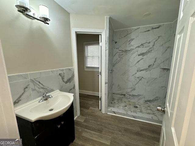 full bathroom featuring wood finished floors, tile walls, wainscoting, a shower stall, and vanity