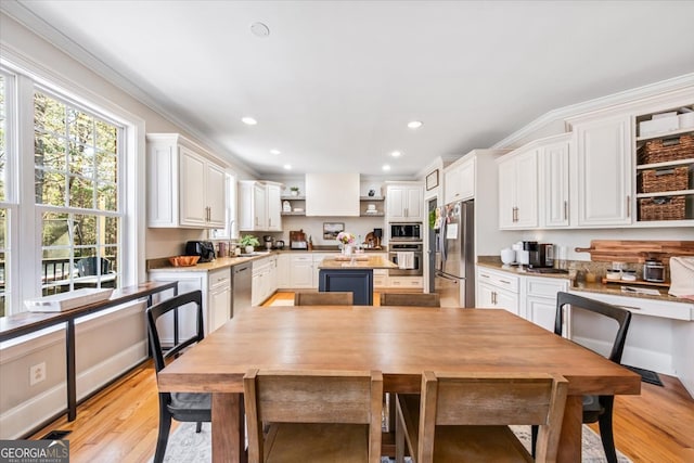 kitchen with light wood finished floors, open shelves, white cabinets, appliances with stainless steel finishes, and a center island