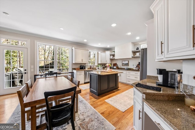 kitchen with open shelves, white cabinetry, stainless steel appliances, light wood-style floors, and a healthy amount of sunlight