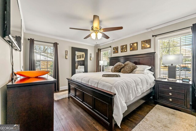 bedroom featuring multiple windows, dark wood-style floors, and ornamental molding