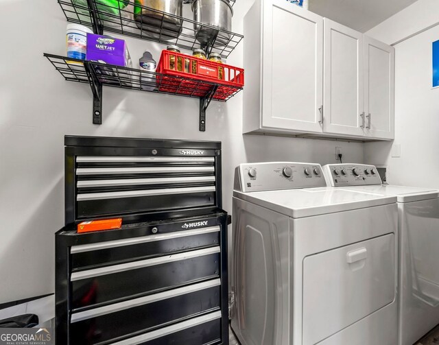 washroom with washer and dryer, cabinet space, and baseboards