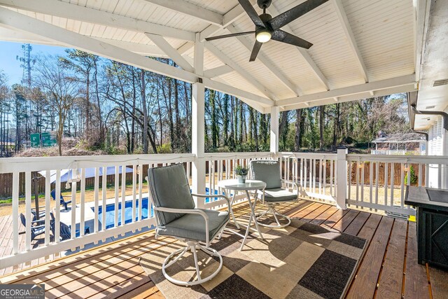 wooden deck with a ceiling fan and an outdoor pool