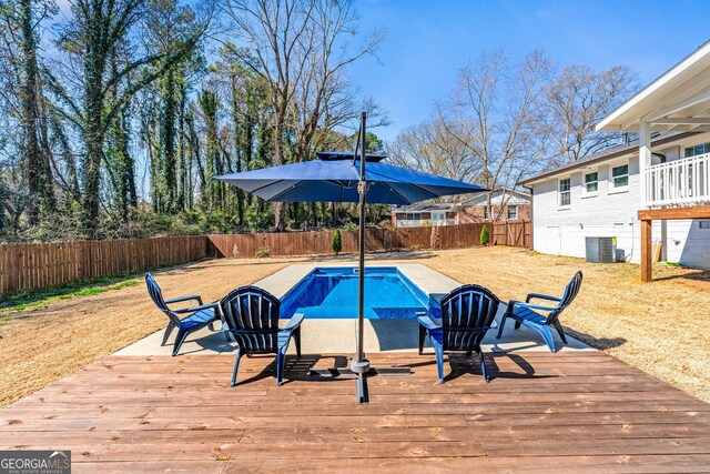 view of swimming pool featuring a fenced in pool, a wooden deck, central AC unit, and a fenced backyard