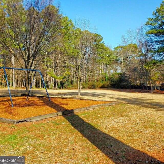 view of home's community with playground community and a yard