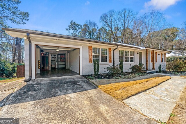 ranch-style house with a garage, brick siding, and concrete driveway