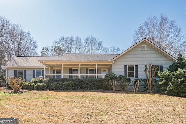 view of front facade featuring roof with shingles, a porch, and a front yard