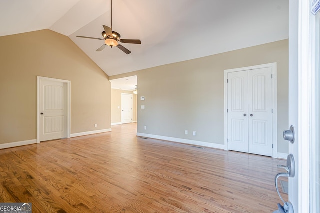 interior space with light wood-style flooring, baseboards, high vaulted ceiling, and ceiling fan