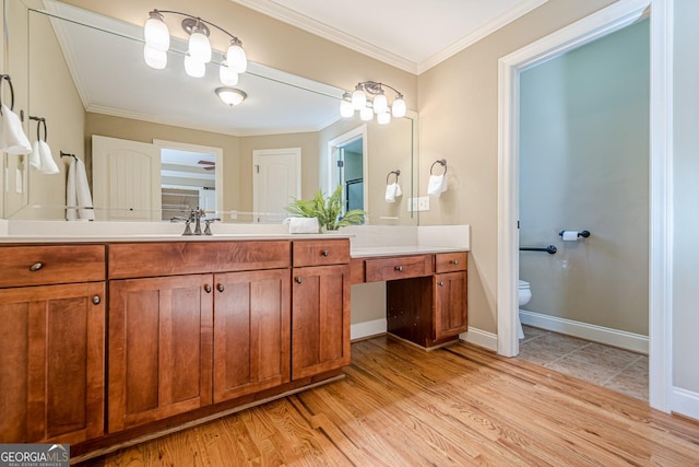 bathroom featuring vanity, toilet, wood finished floors, and ornamental molding