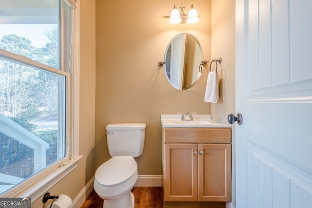 bathroom featuring vanity, toilet, wood finished floors, and baseboards