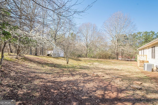 view of yard featuring cooling unit and an outbuilding