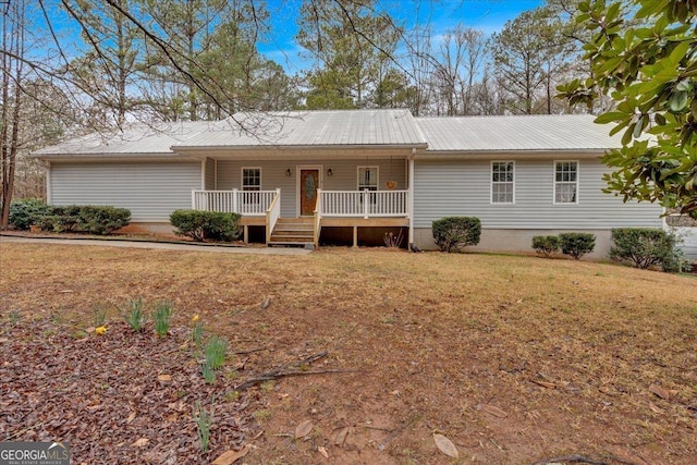 single story home with metal roof, a porch, and a front yard