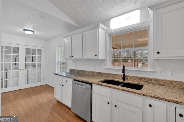 kitchen with white cabinetry, a sink, french doors, light wood-style floors, and dishwasher