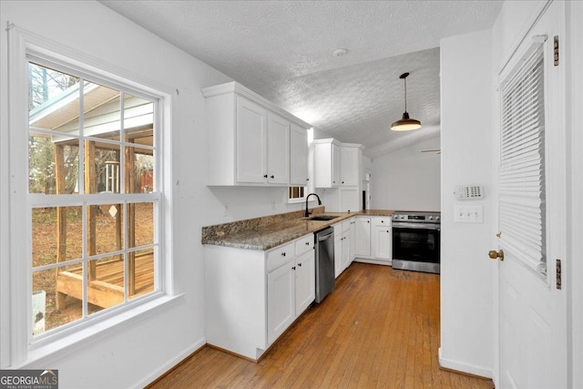 kitchen featuring a sink, stainless steel appliances, light wood-style flooring, and white cabinets