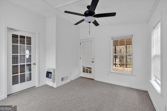 interior space with heating unit, visible vents, a ceiling fan, and baseboards