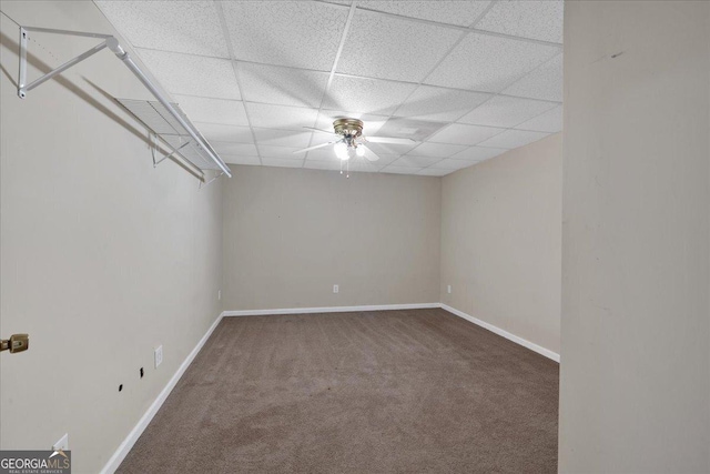 carpeted empty room featuring baseboards, a paneled ceiling, and ceiling fan