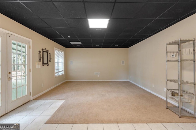 unfurnished room with french doors, carpet, baseboards, and a drop ceiling