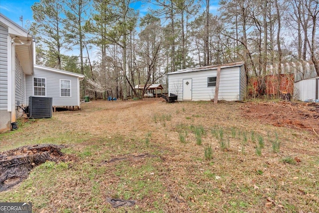 view of yard featuring a storage shed, an outdoor structure, and cooling unit