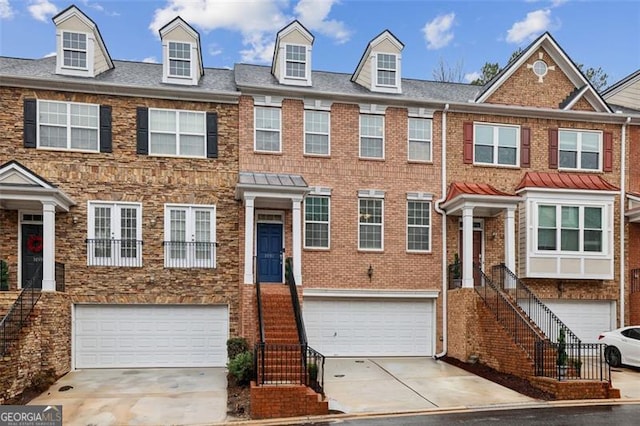 multi unit property with stairs, concrete driveway, and an attached garage