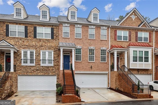 townhome / multi-family property with driveway, a garage, and stairway