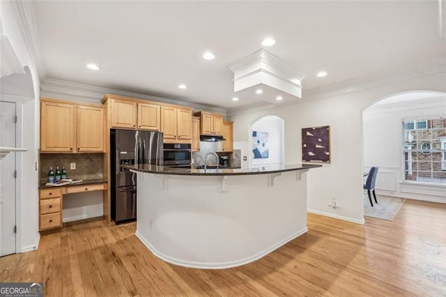 kitchen with black fridge with ice dispenser, wall oven, light wood-style floors, light brown cabinetry, and arched walkways