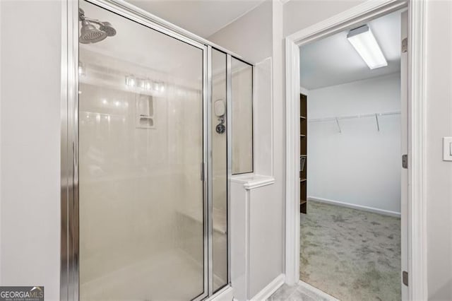 full bath with a spacious closet and a shower stall