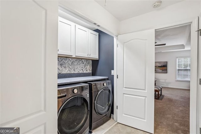 laundry area with baseboards, cabinet space, washing machine and dryer, and light colored carpet