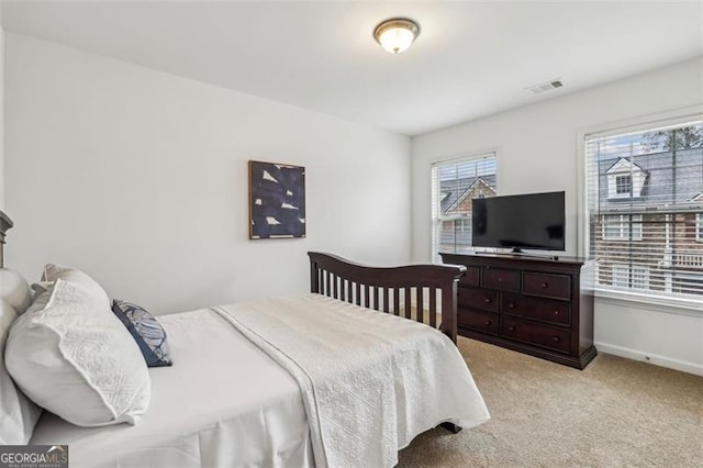 bedroom with baseboards, light colored carpet, and visible vents