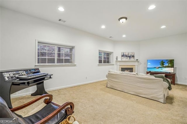 carpeted living area featuring baseboards, visible vents, a lit fireplace, and recessed lighting