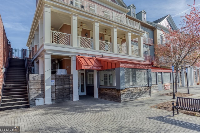 view of front facade featuring stone siding and stairs
