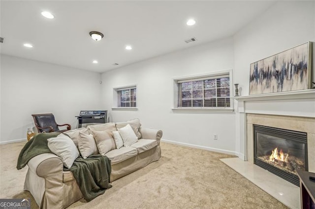 carpeted living area featuring recessed lighting, visible vents, baseboards, and a high end fireplace