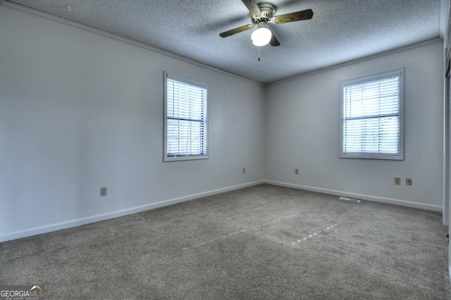 unfurnished room featuring a wealth of natural light, carpet flooring, a textured ceiling, and crown molding