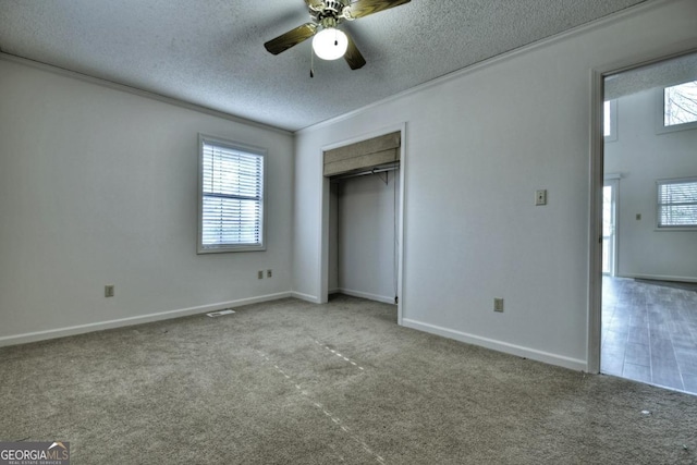 unfurnished bedroom featuring a textured ceiling, carpet, and ornamental molding