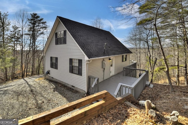 view of side of home featuring crawl space, a wooden deck, roof with shingles, and dirt driveway