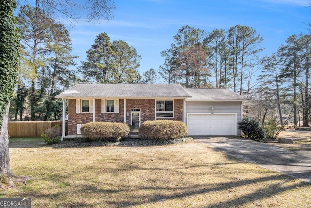 view of front of house featuring driveway, fence, a front yard, a garage, and brick siding