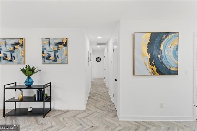 hall with attic access, baseboards, and visible vents