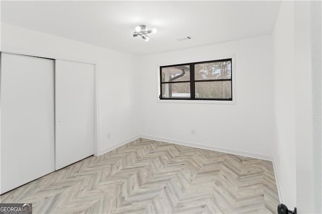 unfurnished bedroom featuring a closet, visible vents, and baseboards