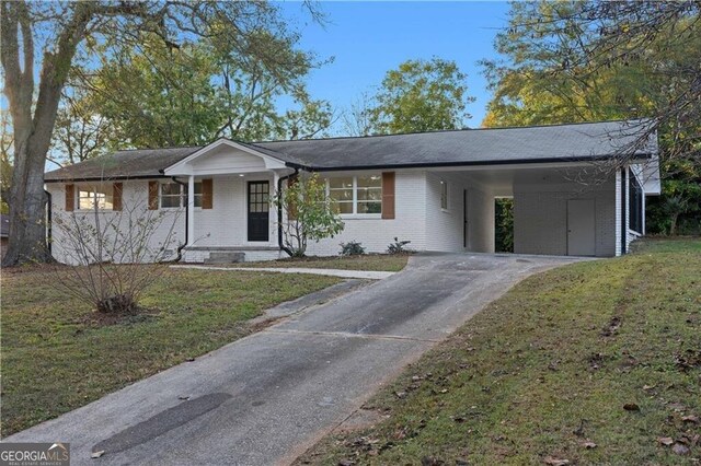 view of front of house featuring a front lawn, a carport, brick siding, and driveway