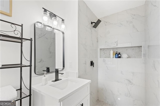 full bath with tiled shower and vanity