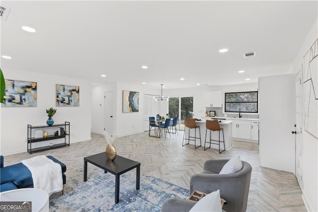 living area with recessed lighting, visible vents, and baseboards